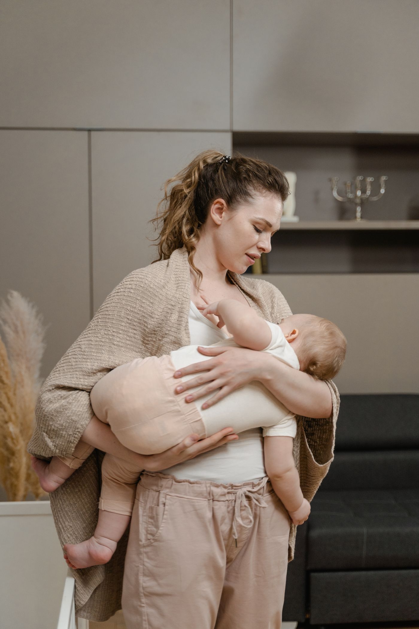 A mother gently cradling her sleeping baby at home