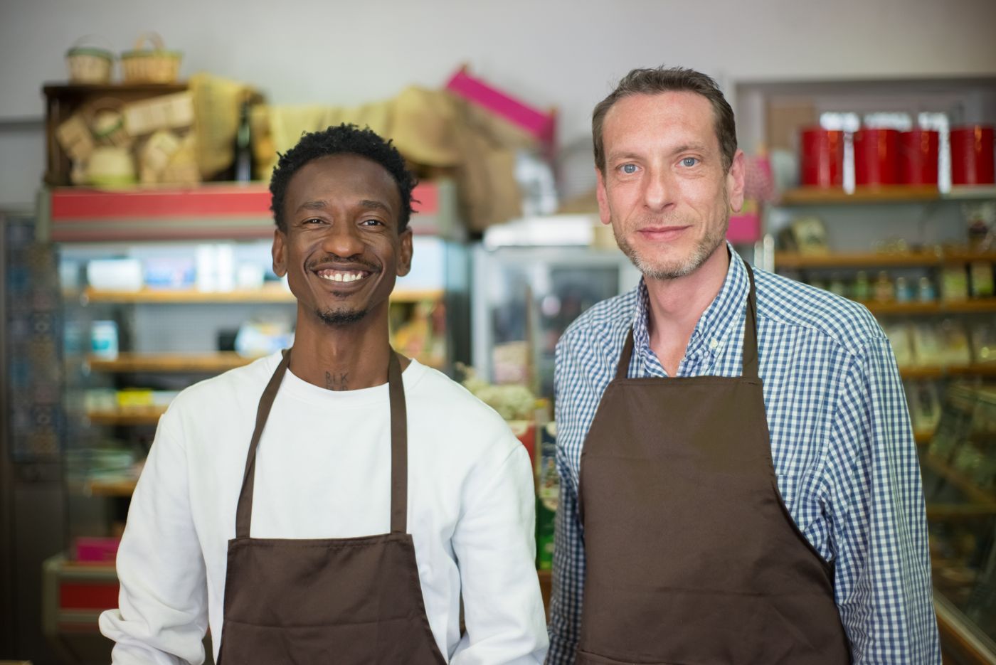 Two smiling shop owners standing in their store